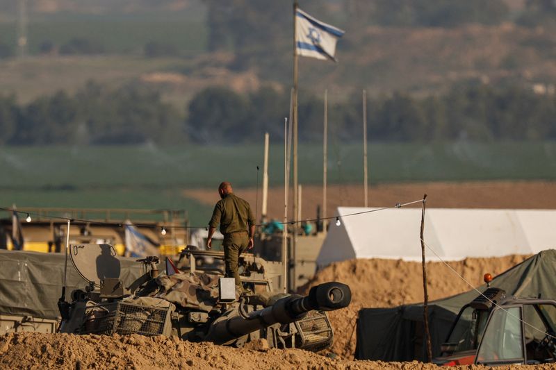 © Reuters. An Israeli solider walks on a mobile artillery unit, amid the ongoing conflict between Israel and the Palestinian Islamist group Hamas, near the Israel-Gaza border in southern Israel, January 20, 2024. REUTERS/Tyrone Siu