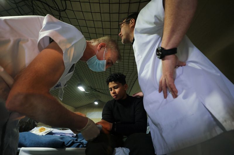 &copy; Reuters. Un niño palestino sentado en una cama mientras recibe tratamiento en el hospital a bordo del buque francés portahelicópteros anfibio Dixmude mientras atraca, en medio del conflicto en curso entre Israel y el grupo islamista palestino Hamás, en la ciud