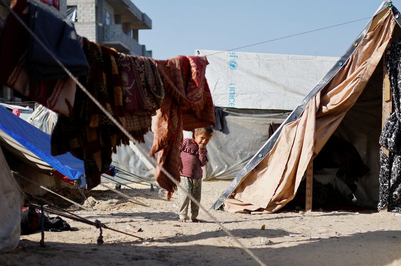 &copy; Reuters. Un niño palestino refugiado, que huyó de su casa debido a los ataques israelíes, observa dentro de un campamento de tiendas de campaña, en medio del actual conflicto entre Israel y el grupo islamista palestino Hamás, en Ráfah, en el sur de la Franja