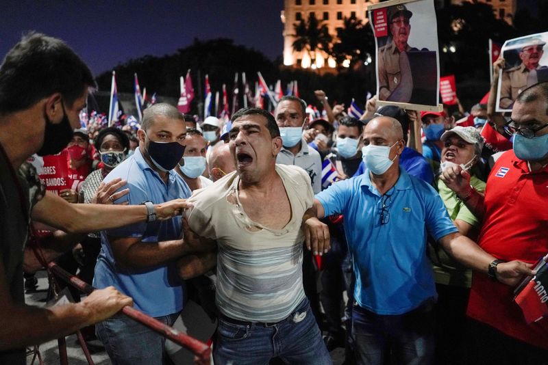 &copy; Reuters. FILE PHOTO: People detain a protester during a rally in Havana, Cuba, July 17, 2021. REUTERS/Alexandre Meneghini