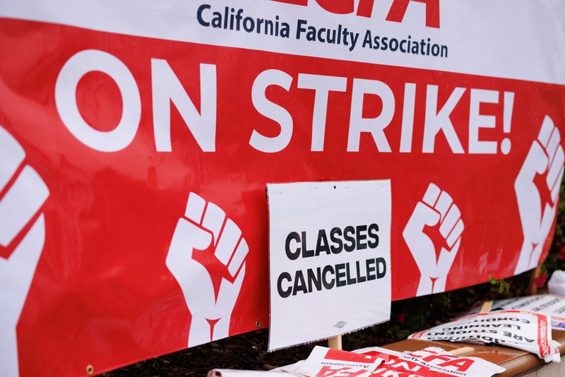 © Reuters. Signs are displayed while picketing begins at San Diego State University as the California Faculty Association, the union representing 29,000 professors, lecturers, librarians, counselors and coaches across the California State University start a planned five-day strike in San Diego, California, U.S. January 22, 2024.  REUTERS/Mike Blake