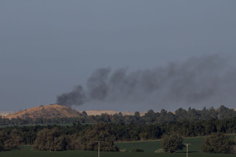 © Reuters. دخان يتصاعد فوق غزة جراء القصف الإسرائيلي كما يبدو من جنوب إسرائيل يوم الأحد. تصوير: تايرون سيو - رويترز.