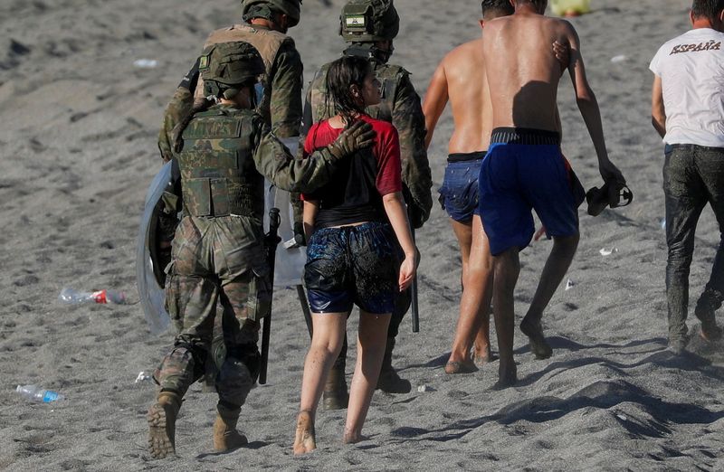 &copy; Reuters. FILE PHOTO: A female migrant is led by a Spanish female soldier as she is deported to Morocco after she crossed the border swimming from Morocco to Spain, at El Tarajal beach, after thousands of migrants swam across this border during last days, in Ceuta,