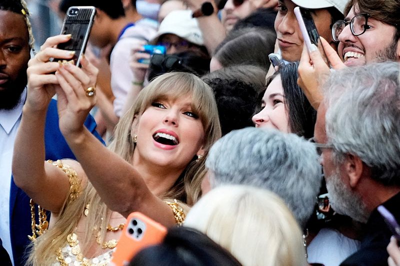 © Reuters. FILE PHOTO: Singer Taylor Swift poses for a selfie with fans as she arrives to speak at the Toronto International Film Festival (TIFF) in Toronto, Ontario, Canada September 9, 2022. REUTERS/Mark Blinch/File Photo