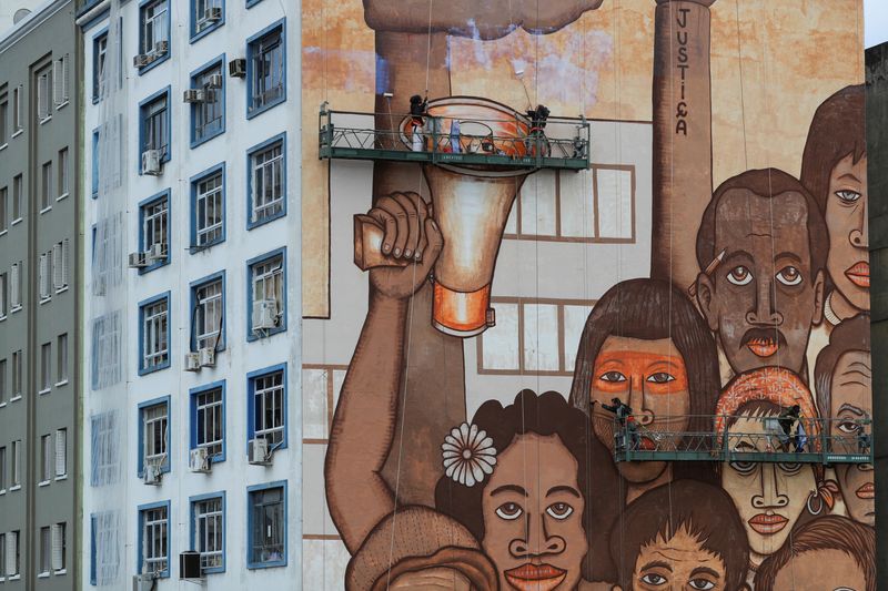 &copy; Reuters. FILE PHOTO: Brazilian artist Mundano works on a mural with different colour paints made with dirt and mud brought from the site of the January 25, 2019 collapsed tailing dam owned by Brazilian mining company Vale SA to honour victims of the disaster, in S