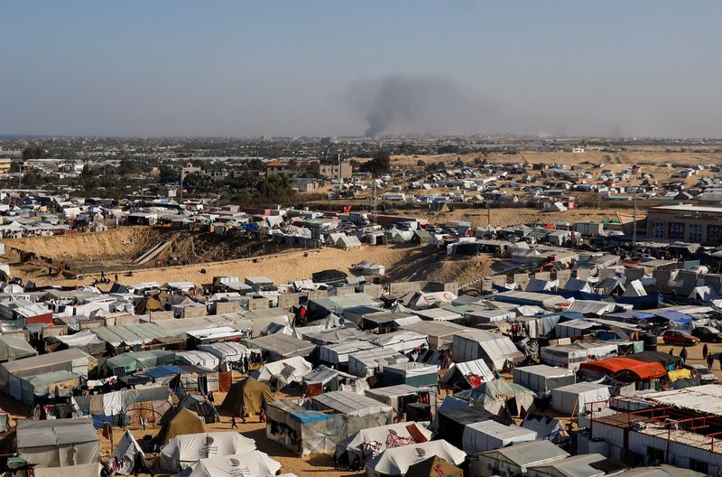 &copy; Reuters. FOTO DE ARCHIVO. Vista general de un campamento de tiendas de campaña que alberga a palestinos desplazados, mientras se eleva humo a lo lejos debido a una operación terrestre israelí en Jan Yunis, en medio del actual conflicto entre Israel y el grupo i