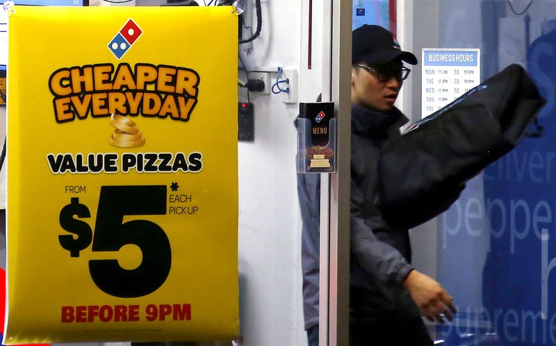 &copy; Reuters. FILE PHOTO: A worker carries a pizza for delivery as he exits a Domino's pizza store in Sydney, Australia, August 12, 2015. REUTERS/David Gray/File Photo