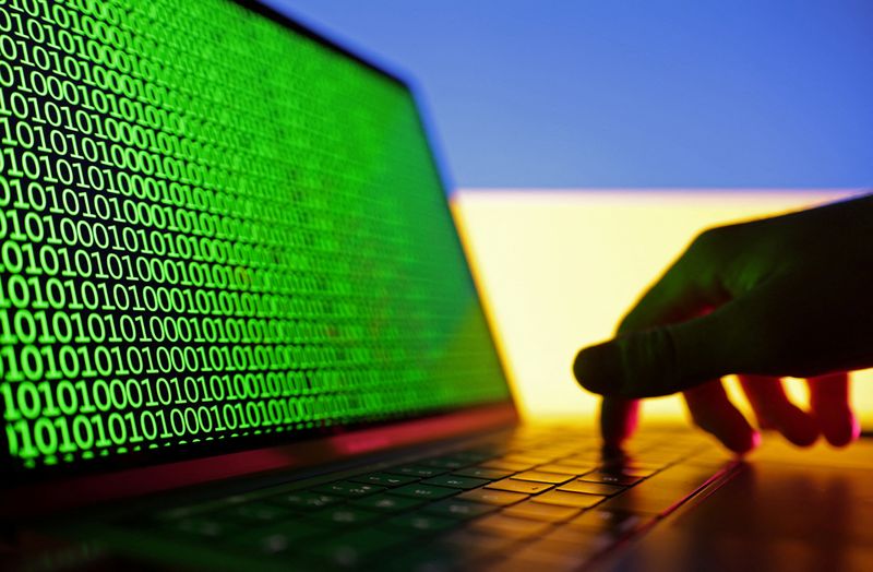 &copy; Reuters. A hand is seen on a laptop with binary codes displayed in front of the Ukrainian flag in this illustration taken, August 19, 2022. REUTERS/Dado Ruvic/Illustration/File Photo