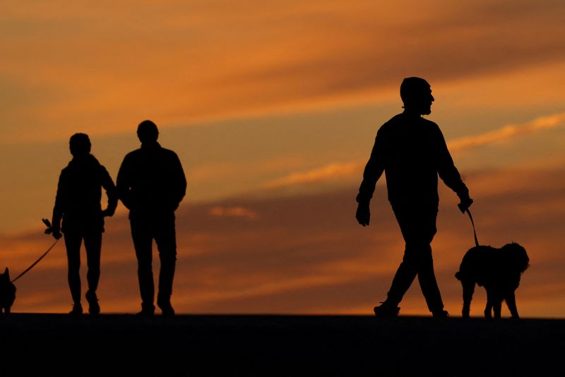 &copy; Reuters. FILE PHOTO: People walk their dogs after sunset in Encinitas, California, U.S., January 9, 2024.  REUTERS/Mike Blake/File Photo