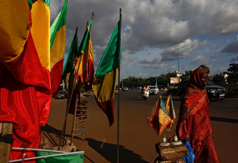 &copy; Reuters. Une femme passe devant des drapeaux maliens à Bamako. /Photo prise le 24 juillet 2018/REUTERS/Luc Gnago