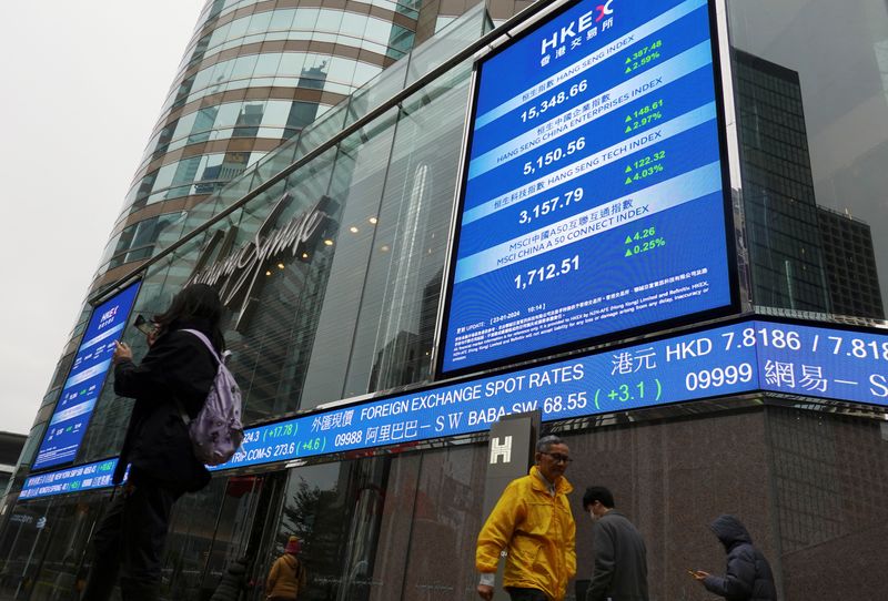 &copy; Reuters. People walk past screens displaying the Hang Seng stock index and stock prices outside the Exchange Square in Hong Kong, China January 23, 2024. REUTERS/Joyce Zhou/ File Photo