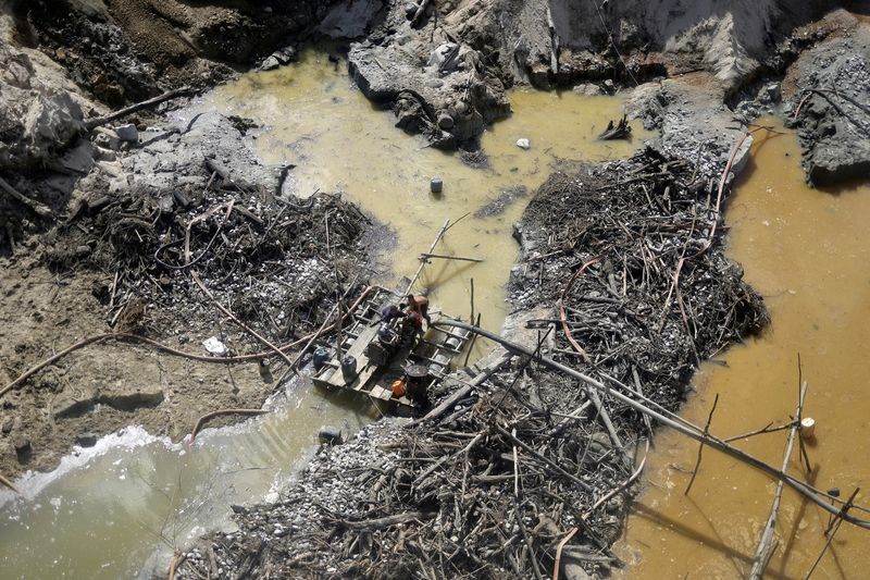 © Reuters. Illegal miners try to throw an engine into the water, when they see approaching members of the Special Inspection Group from the Brazilian Institute of Environment and Renewable Natural Resources (IBAMA), during an operation against illegal mining in Yanomami Indigenous land, Roraima state, Brazil, December 3, 2023. REUTERS/Ueslei Marcelino