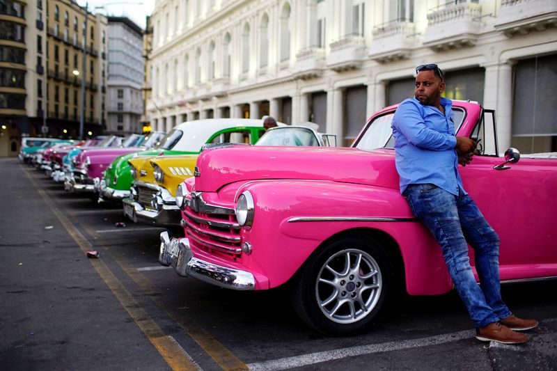 © Reuters. FILE PHOTO: Driver Giovani Bernati waits for tourists beside vintage cars used as taxi in Havana, Cuba, October 5, 2018. Picture taken October 5, 2018. REUTERS/Alexandre Meneghini