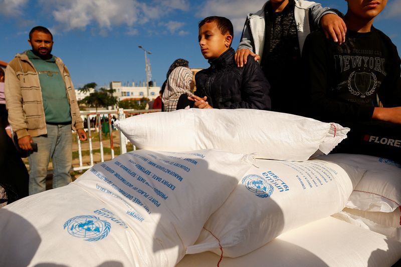 &copy; Reuters. Imagen de archivo de palestinos recobiendo sacos de harina distribuidos por la UNRWA en Rafah, en la Franja de Gaza. 21 noviembre 2023. REUTERS/Ibraheem Abu Mustafa