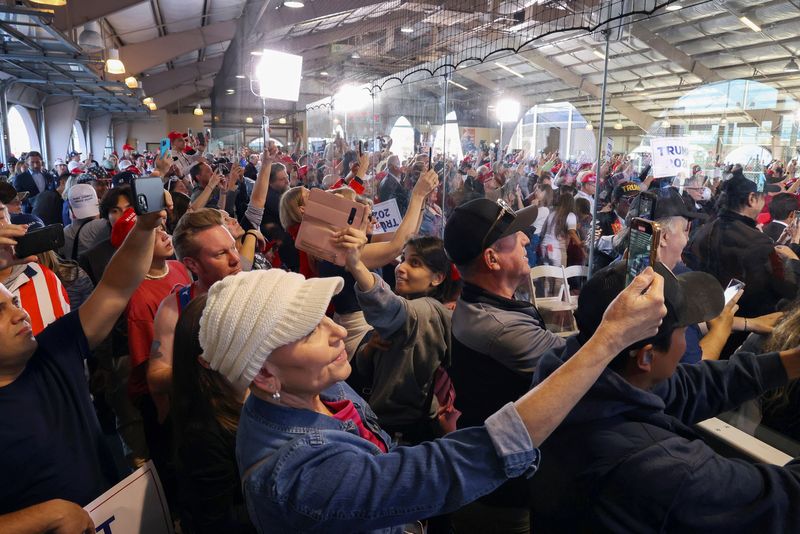 © Reuters. Ginny Lang, front, and other supporters use their mobile phones as they wait for Republican presidential candidate and former U.S. President Donald Trump at a campaign rally ahead of the Republican caucus in Las Vegas, Nevada, U.S. January 27, 2024. REUTERS/Ronda Churchill
