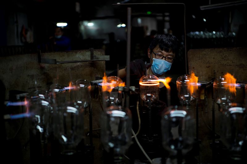 &copy; Reuters. A worker wearing a face mask works on a production line manufacturing glassware products at a factory in Haian, Jiangsu province, China February 29, 2020.  China Daily via REUTERS