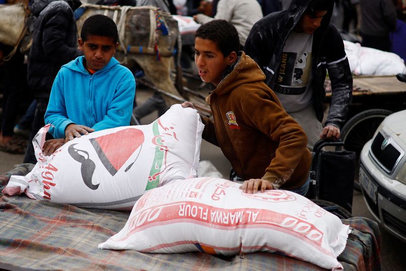&copy; Reuters. A Palestinian boy arranges bags of flour distributed by the United Nations Relief and Works Agency (UNRWA), amid the ongoing conflict between Israel and Hamas, in Rafah in the southern Gaza Strip January 29, 2024.  REUTERS/Ibraheem Abu Mustafa