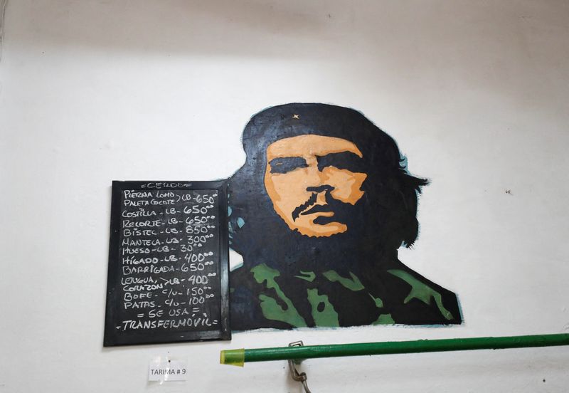 &copy; Reuters. Una tabla de precios cuelga en un puesto de carnicería junto a una imagen del difunto líder rebelde Ernesto "Che" Guevara en un mercado, en La Habana, Cuba 23 de enero 2024. REUTERS/Yander Zamora/Archivo