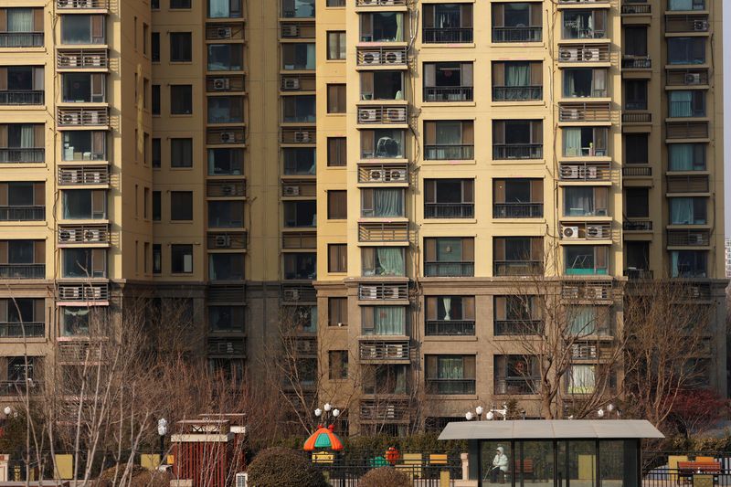 &copy; Reuters. A person sits in front of residential buildings developed by China Evergrande Group, after a court ordered the liquidation of the property developer, in Beijing, China January 29, 2024. REUTERS/Florence Lo