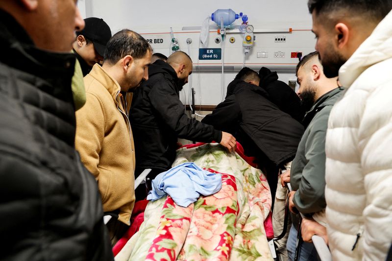 © Reuters. أشخاص بجوار جثة لفلسطيني قتل في مداهمة إسرائيلية بمستشفى في جنين بالضفة الغربية المحتلة يوم الثلاثاء. تصوير: رنين صوافطة - رويترز.
