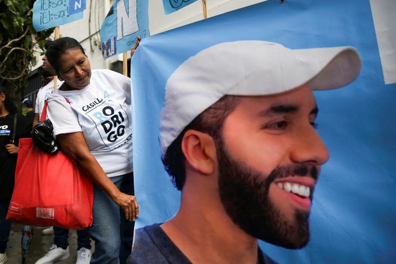 &copy; Reuters. FOTO DE ARCHIVO: Una persona sostiene un cartel con una imagen del presidente de El Salvador, Nayib Bukele, durante un acto de campaña del partido Nuevas Ideas en San Salvador, El Salvador. 20 de octubre de 2023. REUTERS/Jose Cabezas/Archivo