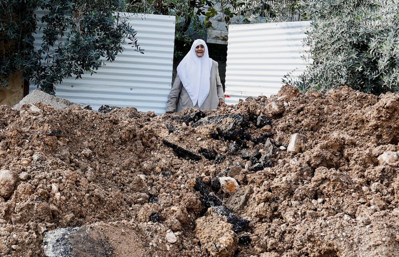 &copy; Reuters. Una donna accanto a una strada danneggiata, dopo un'incursione israeliana, nel campo di Jenin, nella Cisgiordania occupata da Israele, 29 gennaio 2024. REUTERS/Raneen Sawafta