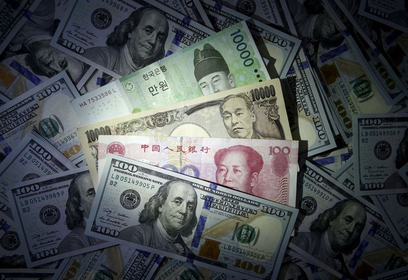 &copy; Reuters. Le banconote in won sudcoreano, yuan cinese e yen giapponese sono visibili sulle banconote da 100 dollari statunitensi in questa illustrazione fotografica scattata il 15 dicembre 2015. REUTERS/Kim Hong-Ji