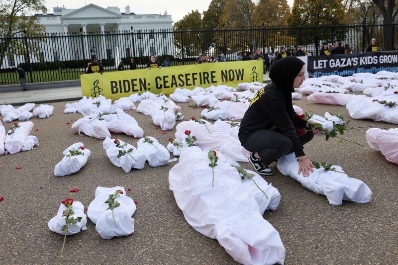 &copy; Reuters. FILE PHOTO: Isra Chaker of Amnesty International USA lays a rose on a prop representing a dead child, during a protest to demand the Israeli government allow unimpeded humanitarian aid to Gaza and a ceasefire in the conflict between Israel and Palestinian