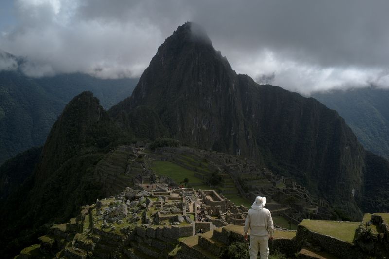 &copy; Reuters. FILE PHOTO: A man stands near the Incan ruins of Machu Picchu, a tourism magnet, access to which is being limited by local protests against rising prices amid a worldwide surge most recently triggered by the Russian invasion of Ukraine, outside of Cuzco, 
