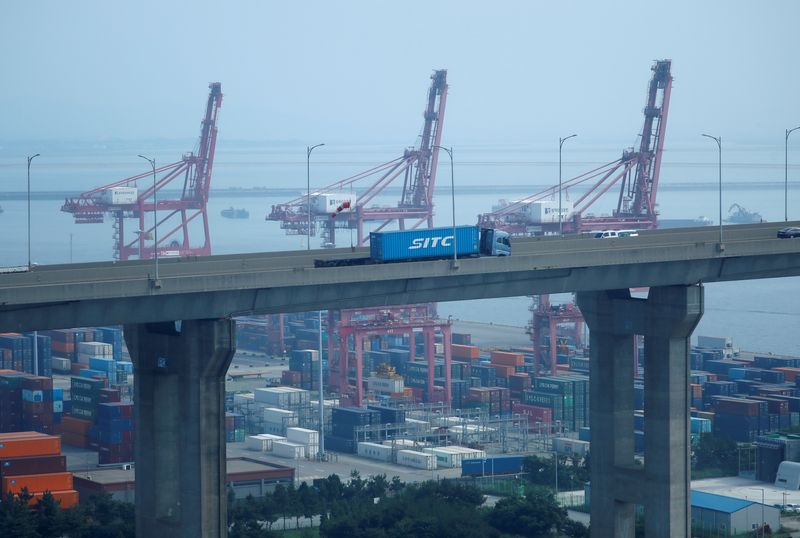 © Reuters. A truck carrying a shipping container travels past cranes at Pyeongtaek port in Pyeongtaek, South Korea, July 9, 2020.    REUTERS/Kim Hong-Ji