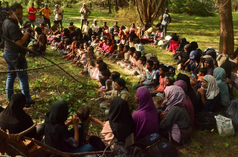 © Reuters. لاجئون من الروهينجا يتجمعون أثناء قيام ضباط من السلطات المحلية بتفتيشهم بعد وصولهم إلى شواطئ إقليم اتشيه الإندونيسي يوم الخميس. تصوير: رويترز. يحظر إعادة بيع الصورة أو الاحتفاظ بها في أرشيف.