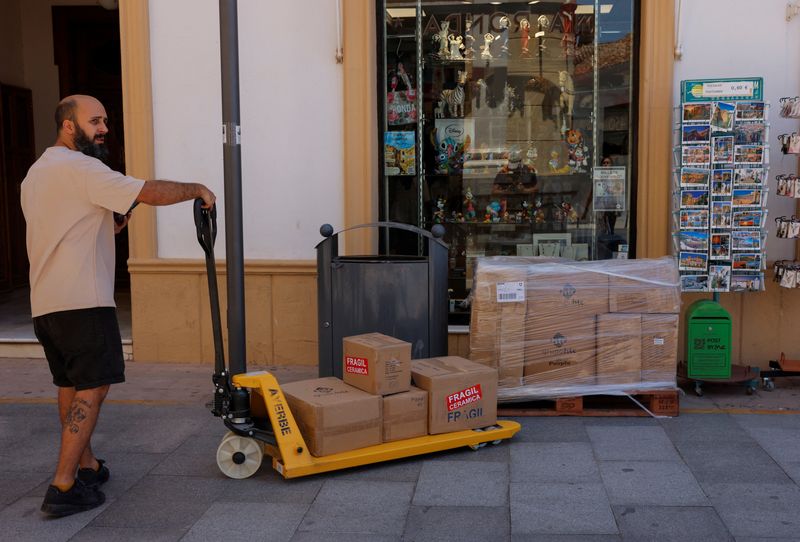&copy; Reuters. Un uomo consegna dei pacchi di fronte ad un negozio di souvenir a Ronda. 4 luglio 2023. REUTERS/Jon Nazca