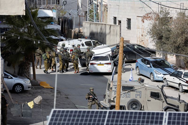 &copy; Reuters. جنود إسرائيليون يقفون بالقرب من موقع حادث لإطلاق النار في الخليل في الضفة الغربية المحتلة يوم الخميس. تصوير: موسى قواسمة - رويترز.