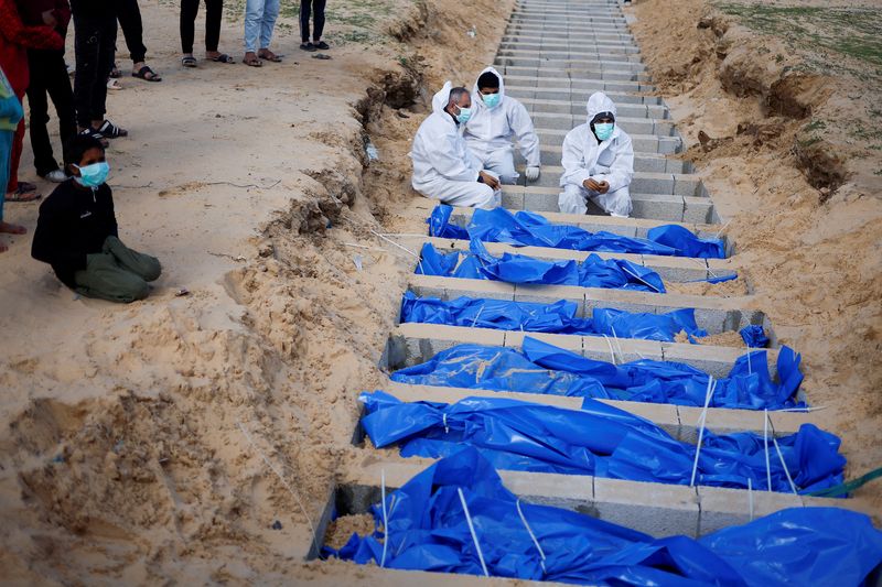 &copy; Reuters. Personas entierran a palestinos, incluidos los que murieron por ataques y disparos israelíes, después de que sus cuerpos fueran liberados por Israel, según funcionarios del Ministerio de Salud palestino en una fosa común en Rafah, en el sur de la Fran