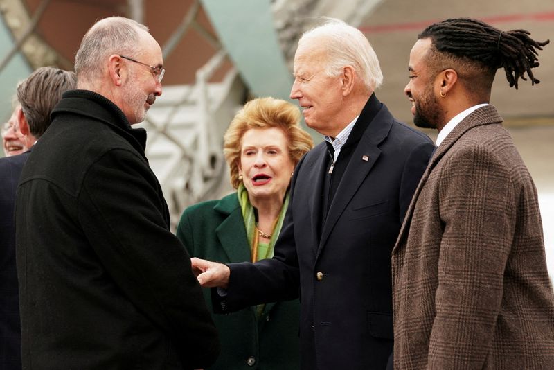 © Reuters. U.S. President Joe Biden, flanked by U.S. Senator Debbie Stabenow (D-MI) and entrepreneur Darren Riley, is greeted by United Auto Workers (UAW) President Shawn Fain as he arrives in the Detroit metro area, Michigan, U.S., February 1, 2024.  REUTERS/Kevin Lamarque