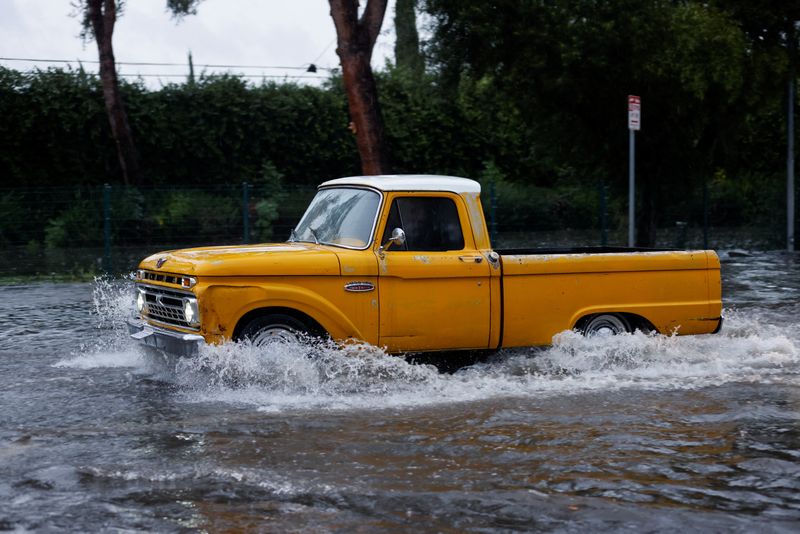 © Reuters. A vehicle drives through flood water in Tarzana, in the San Fernando Valley region of Los Angeles, California, U.S. February 1, 2024. REUTERS/Carlin Stiehl