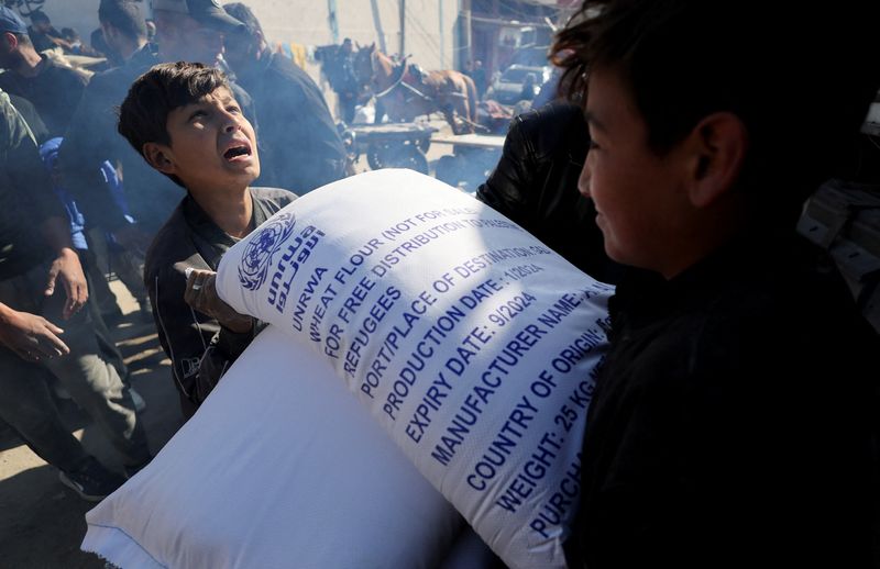 &copy; Reuters. Palestinos recebem sacos de farinha distribuídos por agência da ONU em Rafah, no sul da Faixa de Gaza
01/02/2024 REUTERS/Ibraheem Abu Mustafa