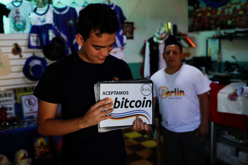 &copy; Reuters. Gerardo Linares, miembro de una comunidad Bitcoin, sostiene carteles recién impresos para colocar en nuevos negocios que aceptarán Bitcoin, en Berlín, El Salvador
Ene 24, 2024. REUTERS/Jose Cabezas