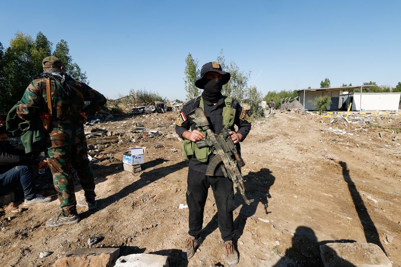 © Reuters. مقاتلون تابعون لكتائب حزب الله العراقية المسلحة يقفون في موقع غارة أمريكية بالحلة في العراق يوم 26 ديسمبر كانون الأول 2023. تصوير: علاء المرجاني - رويترز.