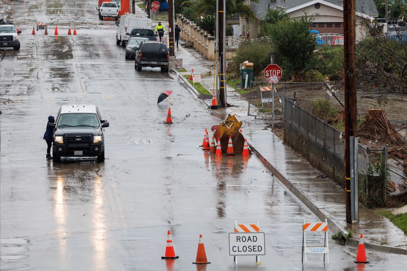 &copy; Reuters. الشرطة تغلق طريقا غمرته المياه بعد هطول أمطار غزيرة خلال عاصفة بكاليفورنيا يوم الجمعة. تصوير: مايك بليك - رويترز.