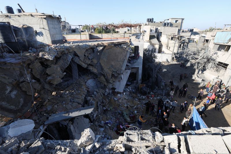 &copy; Reuters. فلسطينيون يتفقدون موقع منزل تدمر جراء الغارات الإسرائيلية في رفح بجنوب قطاع غزة يوم السبت. تصوير: إبراهيم أبو مصطفى - رويترز.