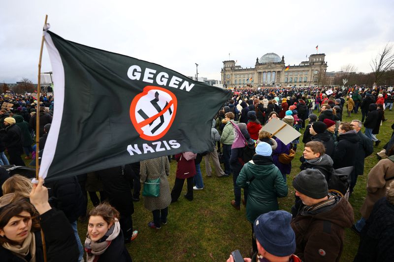 © Reuters. متظاهر يحمل لافتة ضخمة بينما يحتشد متظاهرون أمام مبنى البرلمان الألماني بالعاصمة برلين يوم السبت في احتجاج مناهض لحزب البديل من أجل ألمانيا اليميني المتطرف . تصوير : فابرتسيو بنش - رويترز . 