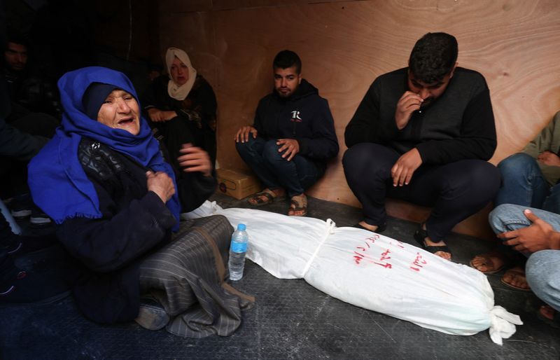 © Reuters. أسرة أحد الأطفال الفلسطينين الذين قتلوا جراء الغارات الإسرائيلية بجوار جثمانه في رفح بجنوب قطاع غزة يوم الأحد. تصوير إبراهيم أبو مصطفى - رويترز.