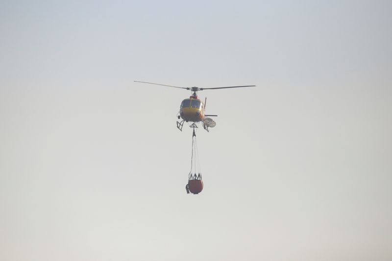 &copy; Reuters. Un hélicoptère équipé d'un seau d'eau survole une zone brûlée pour éteindre un incendie à Vina del Mar, au Chili. /Photo prise le 3 février 2024/REUTERS/Sofia Yanjari