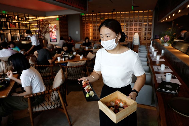 © Reuters. FILE PHOTO: A staff member serves sushi dishes for customers at a Japanese restaurant in Beijing, China September 7, 2023. REUTERS/Tingshu Wang/File Photo