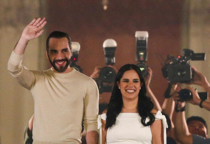 © Reuters. El Salvador's President, Nayib Bukele, who is running for reelection, greets supporters from the balcony of the National Palace next to his wife Gabriela de Bukele, after declaring himself the winner in the presidential election in San Salvador, El Salvador, February 4, 2024. REUTERS/Jose Cabezas     
