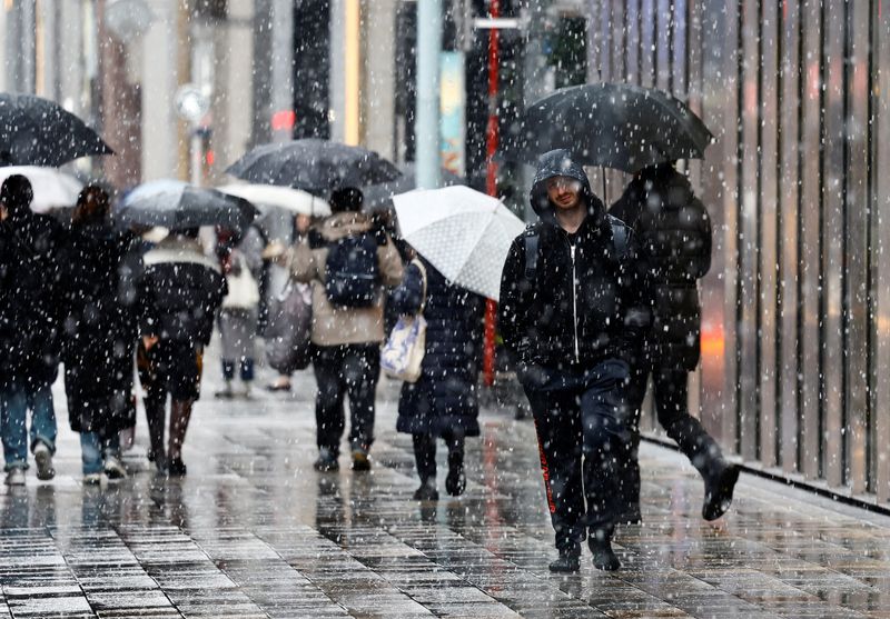 &copy; Reuters. 関東甲信を中心とした大雪の影響で自動車メーカー各社が５日、一部工場の稼働を停止した。写真は雪の中を歩く人々。東京・銀座で５日撮影。（2024年 ロイター/Issei Kato）