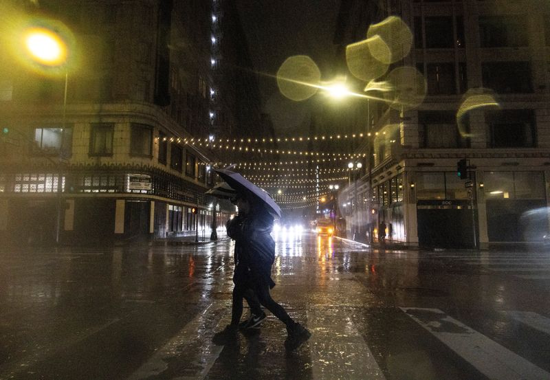 &copy; Reuters. People walk downtown during heavy rains in Los Angeles, California, U.S., February 4, 2024.  REUTERS/Aude Guerrucci