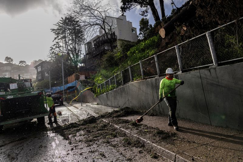 &copy; Reuters. FOTO DE ARCHIVO. Trabajadores limpian un área de un árbol caído mientras una tormenta del Pacífico conocida como "Río Atmosférico" se acerca al norte de California, trayendo fuertes lluvias y vientos que podrían provocar inundaciones generalizadas,