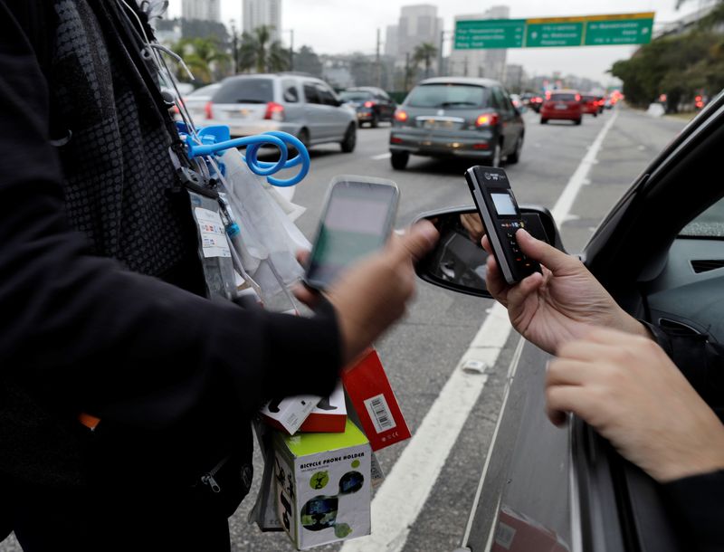 © Reuters. Vendedor ambulante recebe pagamento por cartão de crédito durante horário de pico em avenida de São Paulo
16/08/2018 REUTERS/Paulo Whitaker